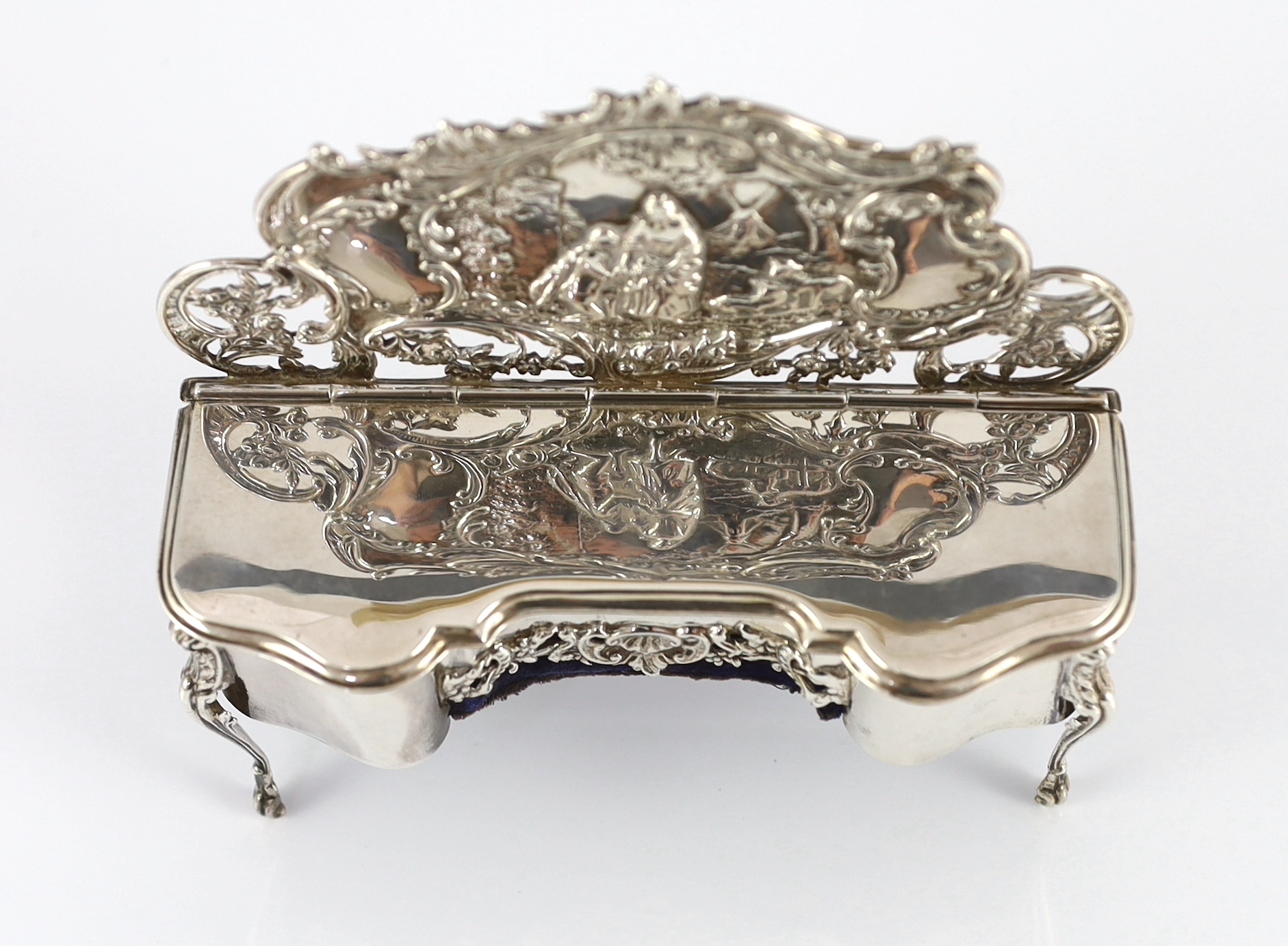 An Edwardian embossed silver novelty trinket box, modelled as a dressing table with raised back, on cabriole legs, by William Comyns